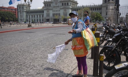 Gladys Serrano, 60, wearing a mask against the spread of the new coronavirus, shows a white flag while standing at Constitution Square in Guatemala City on 4 May.