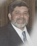 Mazzen Dabbagh, bearded in suit, smiling jovially