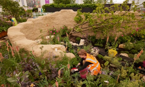 A Chelsea flower show worker tending to the Choose Love gardem