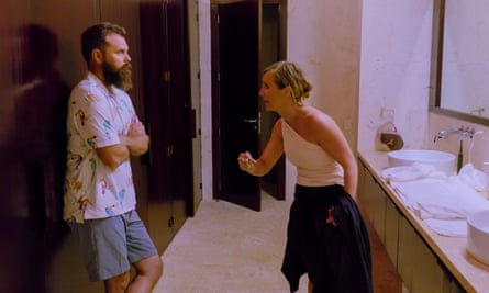 A woman gestures emphatically at a man in a bathroom