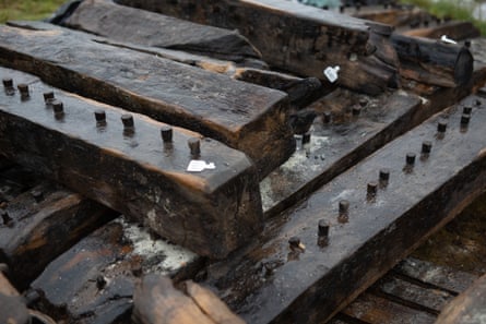 they are dark and wet, with lines of protruding wooden pegs that held them together
