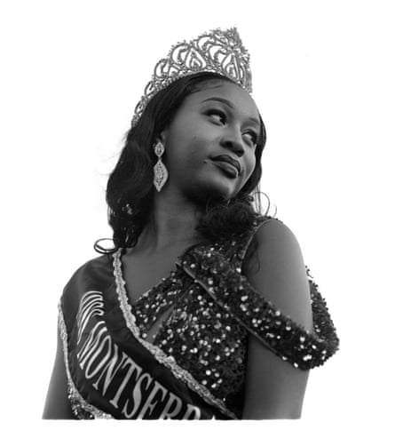 A person in a beauty pageant crown and sash looks over her left shoulder