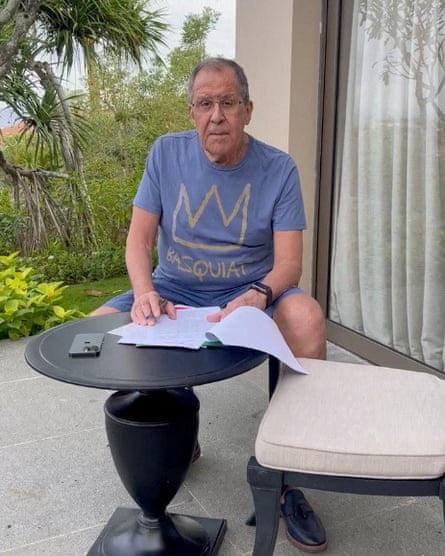 Sergei Lavrov reads documents on a patio in Bali, Indonesia