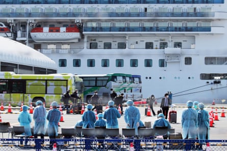 Workers in protective gear prepare to check passengers after they disembarked the Diamond Princess cruise ship at the Daikoku Pier Cruise Terminal in Yokohama, Japan, 21 February 2020.