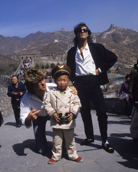Ridgeley and Michael standing with a small boy wearing a military-style uniform