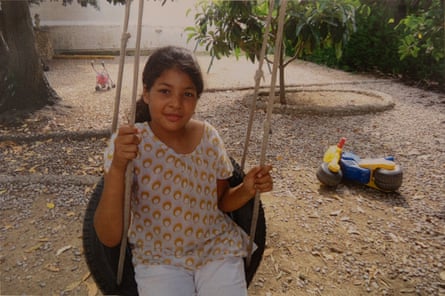 Young girl sits on a tyre swing