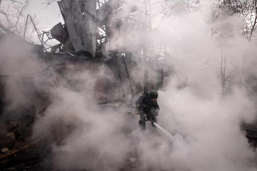 A firefighter works to extinguish a fire at a warehouse caused by recent Russian shelling in Kharkiv.