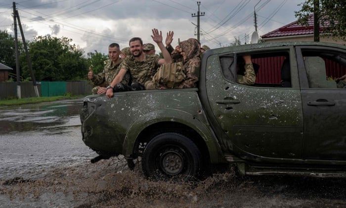 TOPSHOT-UKRAINE-RUSSIA-CONFLICT-WARTOPSHOT - Ukranian soldiers wave from the back of a pick-up as they drive to the frontline during a rainy day in the city of Sloviansk, eastern Ukraine, on August 2, 2022, amid the Russian invasion of Ukraine. (Photo by BULENT KILIC / AFP) (Photo by BULENT KILIC/AFP via Getty Images)