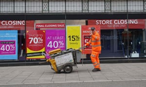 Signs in the window of a closing Debenhams store offer sales bargains on the High Street in Winchester.