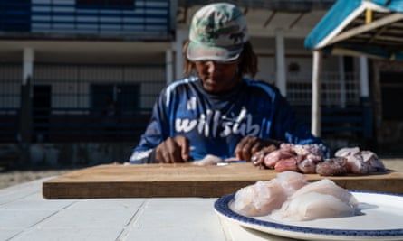 Three prepared lionfish laid on a chopping board next to some raw lionfish cuts