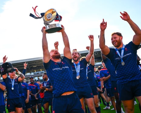 London Broncos rugby players celebrate, lifting the Championship Grand Final trophy.