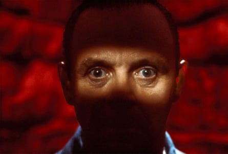 Close up of Anthony Hopkins against a red background with staring eyes spotlit - as Hannibal Lecter in The Silence of the Lambs