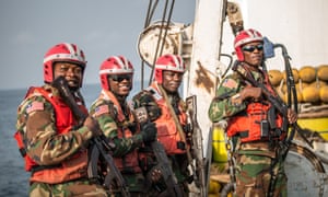 Members of Liberia’s coastguard board a ship suspected of fishing illegally in the country’s waters