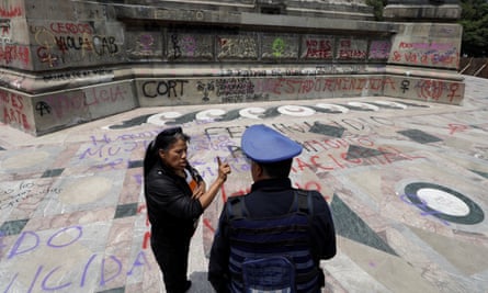 A woman speaks with a police officer near the Angel of Independence monument in Mexico City