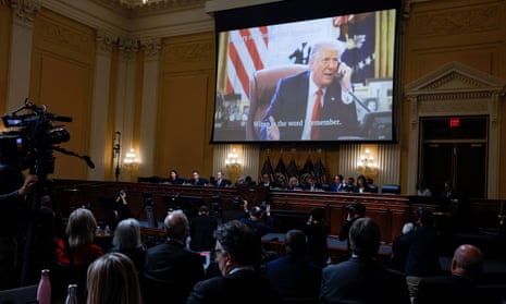 An image of Trump is seen above the members of the January 6 committee during their final meeting on 19 December. 