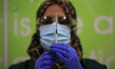A health worker prepares a coronavirus vaccine at a pop-up Covid-19 vaccination clinic operating at the MyLahore British Asian Kitchen in Bradford, West Yorkshire on December 23, 2021.