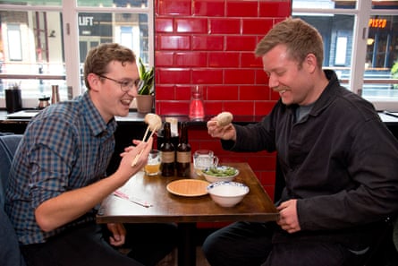 Joe and Stuart eating and laughing across the restaurant table