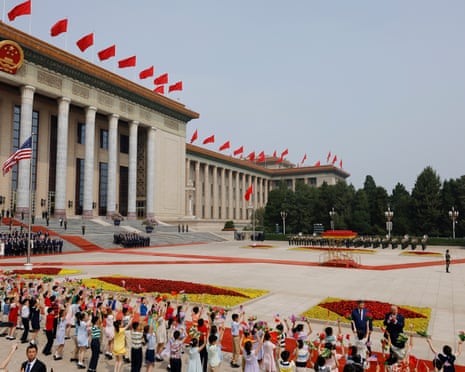 Children wave Chinese and US flags during Trump’s welcome ceremony hosted by Xi, with the two leaders bottom right