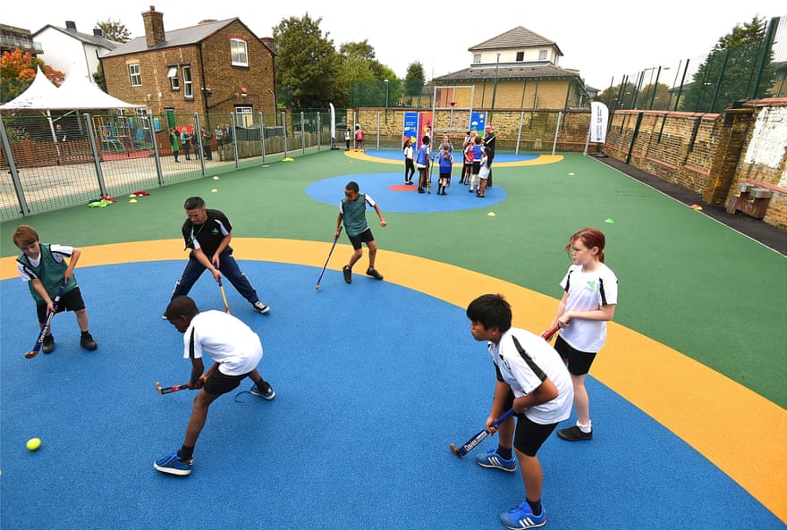 Students at Woodhill Elementary School celebrate the opening of a new multi-purpose sports facility in October 2014 by playing hockey. Greenwich, London's first school to be completed, received her £30,000 state lottery funding from Sport England's Primary Space Fund. that playground.