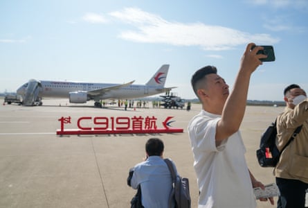 Passengers take photos with a C919, China’s self-developed large passenger aircraft