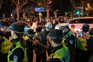 Police officers confront a man as they block Wulumuqi street, in Shanghai.