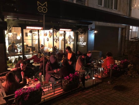 People sitting at tables outside FatCat, Istanbul, at night