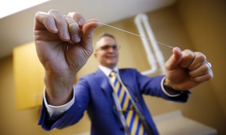 Wayne Aldredge, president of the American Academy of Periodontology, holds a piece of dental floss.