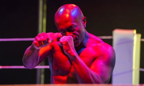 Mensah Bediako, as Vernon, assumes a boxing stance, bathed in red and pink light.