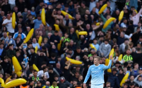 Erling Haaland celebrates a goal in front of Manchester City fans holding inflatable bananas.