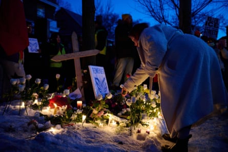Woman lays flowers at a vigil