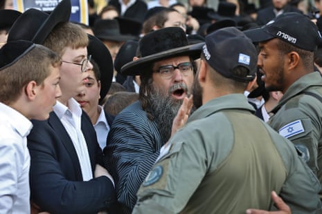 An ultra orthodox Jew clashes with Israeli officers outside an army recruitment office in Jerusalem on Thursday evening.