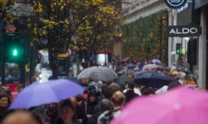 People shopping on Oxford Street in London during wet weather.
