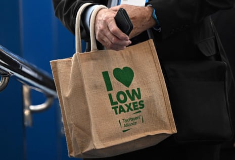 A Conservative Party meeting attendee carries a Taxpayers Union bag to a Conservative Party meeting.