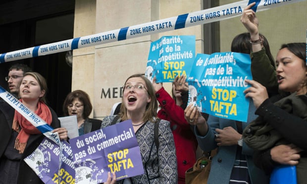Members of the “Stop TAFTA” collective stand outside the building of French employers’ organisation after being removed for interrupting the Transatlantic Trade and Investment Partnership (TTIP) conference in Paris. 
