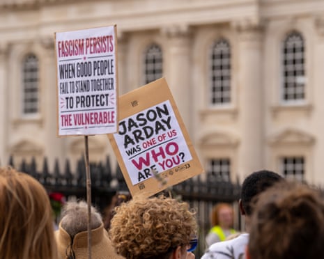 Crowd of people in which someone is holding up a sign that says: 'Jason Arday was one of us: who are you?'