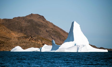 An iceberg in front of a scorched shore