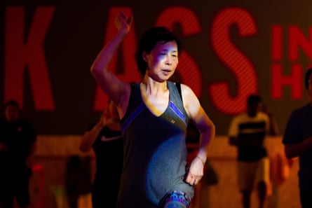 A middle-aged Asian woman in a black singlet in a dance class.