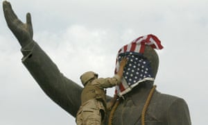 A US Marine covers the face of a statue of Saddam Hussein in Baghdad. Photograph: Ramzi Haidar/AFP via Getty Images