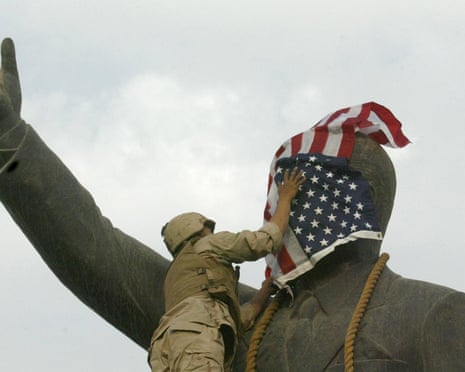 A US Marine covers the face of a statue of Saddam Hussein in Baghdad. Photograph: Ramzi Haidar/AFP via Getty Images