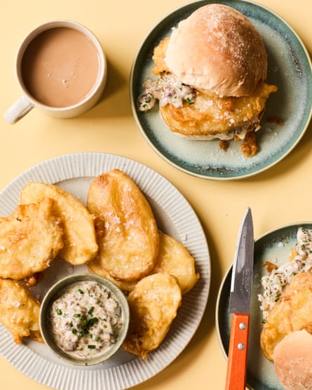 Ali Stoner’s chippy batter potato fritters on a plate with pickled onion mayo, and other fritters in a bread roll, with a cup of tea on the table