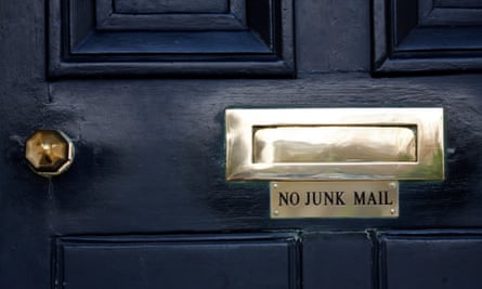 A sign saying no junk mail under the letterbox of a front door of a house in west London.