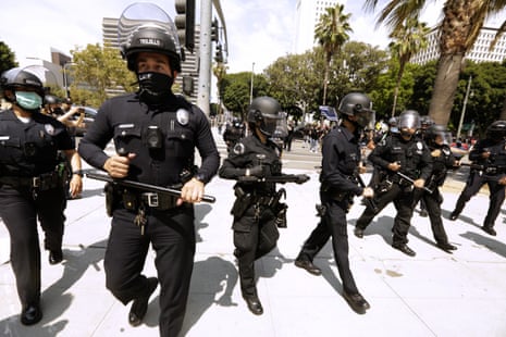 Los Angeles police officers survey a protest in downtown Los Angeles on 14 August. 