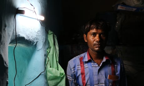 Rajesh stands beside a solar light installed in his home by a student group – one of two functioning lights in the entire village of Rajghat