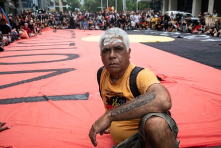 The crowd sits down in front of the Downing Centre courts the rally in Sydney