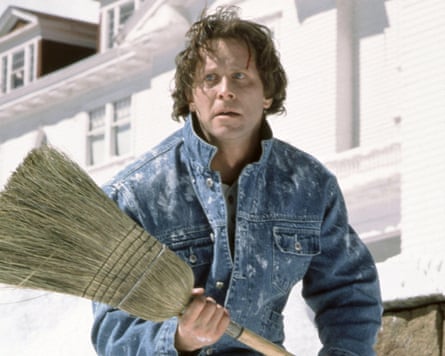 Steven Weber in a denim jacket holding a broom.