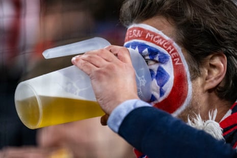 Bayern Munich fan with a painted logo on his face drinks beer during the Champions League quarter-final second leg match against Arsenal.