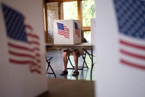 a person sits at a voting booth