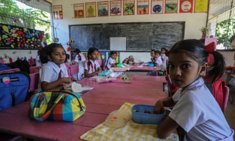 Sri Lankan students have their breakfast in their classroom at a school in Colombo