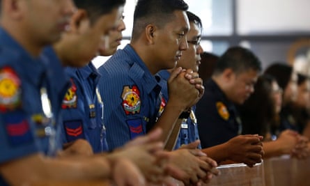 Filipino police pray during a mass held to support Duterte’s anti-drugs campaign.