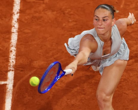 Marta Kostyuk stretches to hit a forehand on a clay court